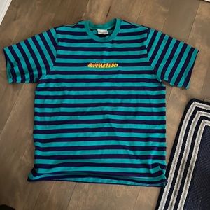 It’s a blue and purple striped T- shirt that’s in good condition.